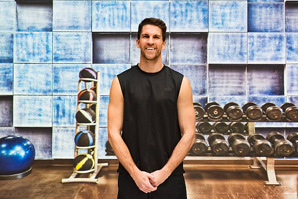 istock Smiling muscular man standing in gym 537890638
