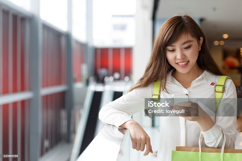 asian beautiful woman shopping and using smart phone indoor asian beautiful woman shopping and using smart phone indoor,consumerism and telecomunication concept 2015 Stock Photo