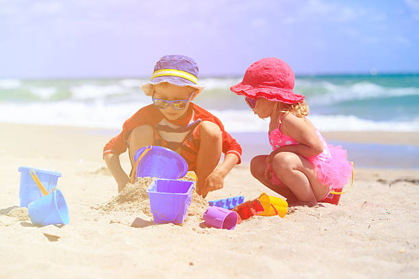 istock kids play with sand on summer beach 537890944