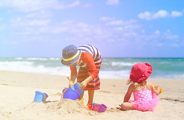 istock kids play with sand on summer beach 537891000