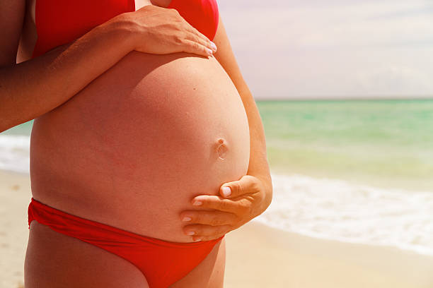istock Happy pregnant woman at beach 537891644