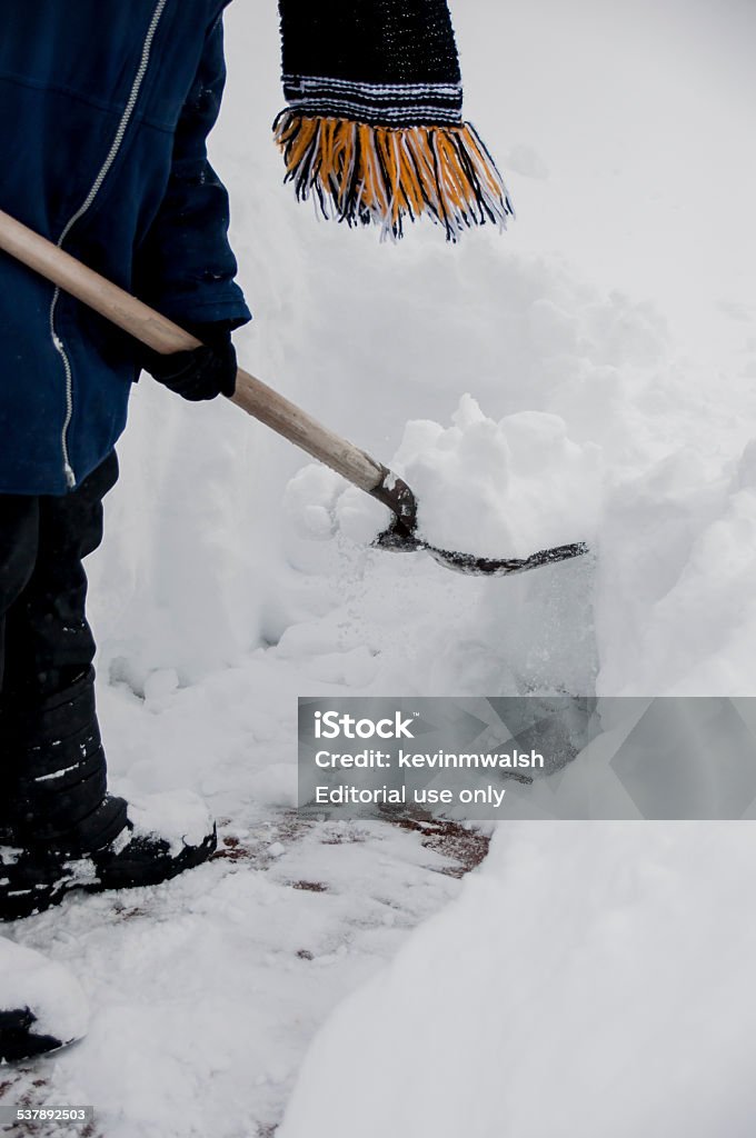 Shoveling Deep Snow Weymouth, MA, USA-February 15, 2015: After a New England blizzard, a person gets out on a cold day to shovel deep snow from his walkway. 2015 Stock Photo