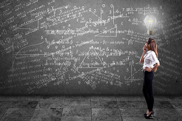 Businesswoman solving mathematical equation Side profile of a businesswoman solving mathematical equation on wall. trigonometry stock pictures, royalty-free photos & images