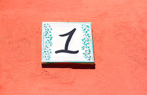 istock Number 1 Street Address Tile on Vibrant Orange-Pink Wall 537903934