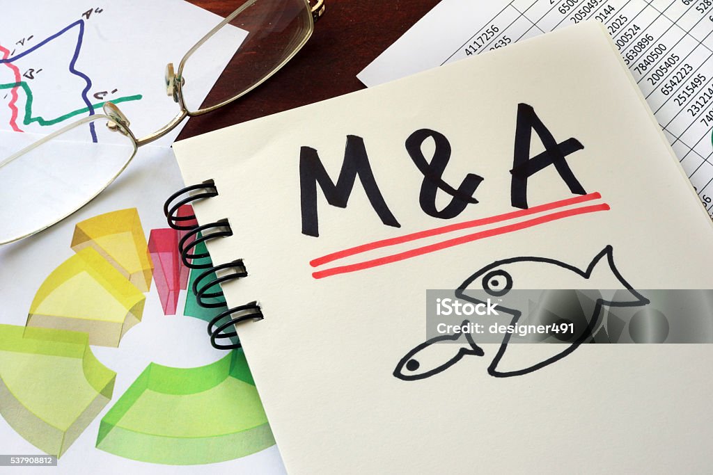 M&A Merger And Acquisitions written on a notepad. M&A Merger And Acquisitions written on a notepad with marker. Mergers and Acquisitions Stock Photo