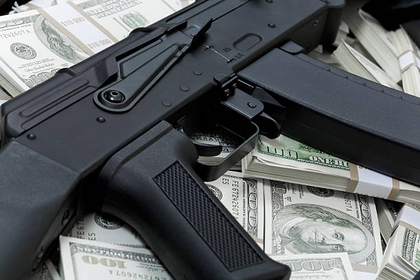 финансовое преступления - guns and money стоковые фото и изображения