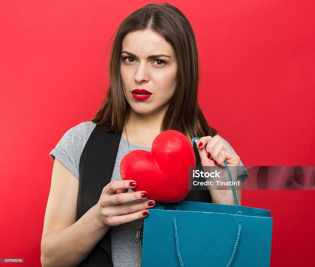 Can't buy me love Beautiful woman holding red heart and shopping bags 2015 Stock Photo