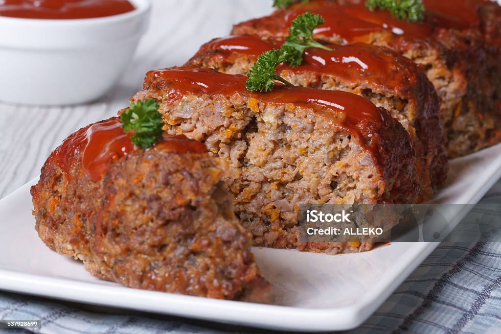 sliced meatloaf with ketchup and parsley horizontal sliced meatloaf with ketchup and parsley closeup on a white plate, horizontal Meat Loaf - Food Stock Photo