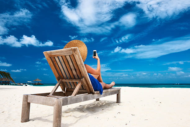 istock Young woman with mobile phone at the beach 537929189