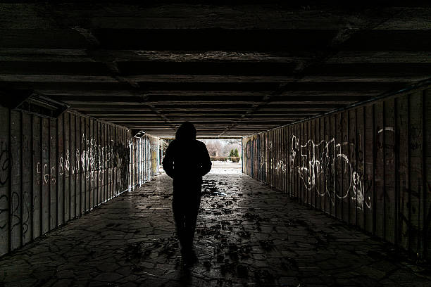 Silhouette of a man in tunnel stock photo
