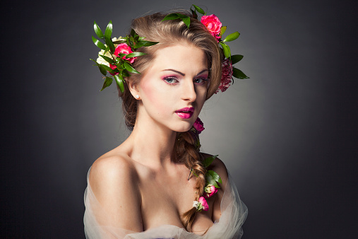 Floral arrangement as a wreath on a head of a brunette woman.