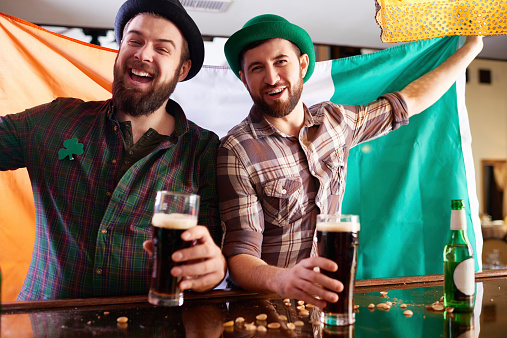 Two cheerful bearded men celebrating St Patricks Day at pub