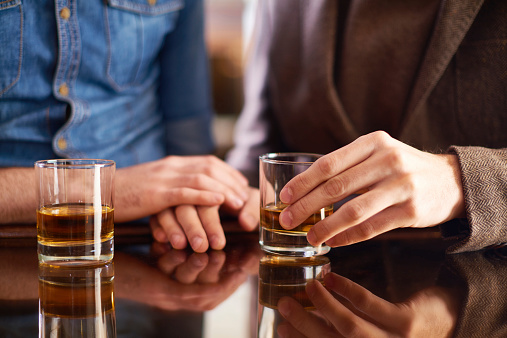 Bromantic couple drinking whisky at bar