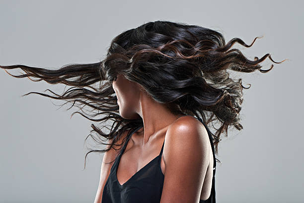 Now this is a hairstyle! Studio shot of a young woman with beautiful hair isolated on gray black hair stock pictures, royalty-free photos & images