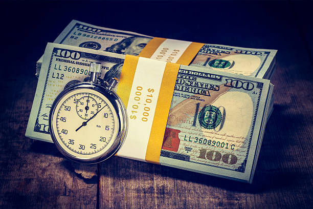 時は金なり - finance photography us currency stopwatch ストックフォトと画像