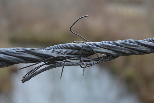 A bridge cable beginning to snap under pressure.