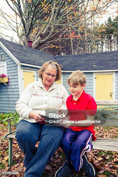 Grandmother Using A Tablet With Her Grandson Outside Stock Photo - Download Image Now