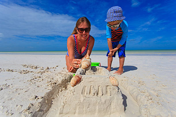 istock mother and son building sand castle on tropical beach 537988977