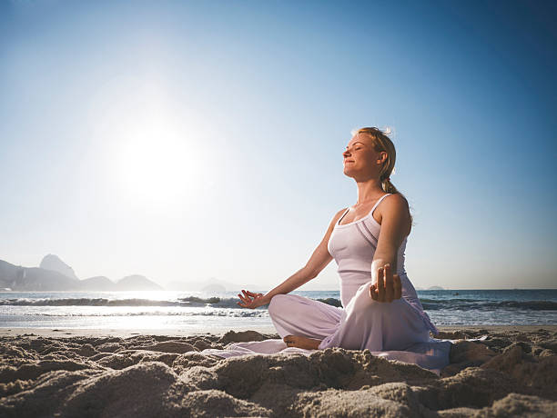 istock Woman meditating on the beach. 537989429