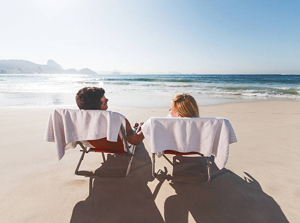 istock Couple relaxing in deck chair at the beach. 537989431