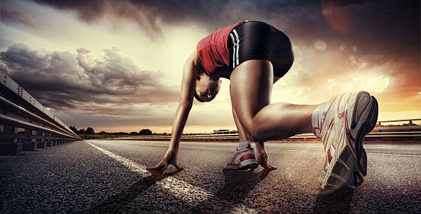 Sport. Runner low angle view of female runner running down road wearing trainers starting line stock pictures, royalty-free photos & images