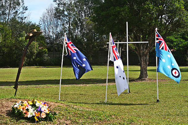 ANZAC Day Army Rifle, Slouch hat & Australian Service flags Landscape (with room for copy) of an upturned, vintage Australian Army 303 rifle, a soldier's dogtags, slouch hat, floral wreath and the Australian Army, Navy and Air force (RAAF) flags flying in the background during an ANZAC Day memorial service. larrikin stock pictures, royalty-free photos & images