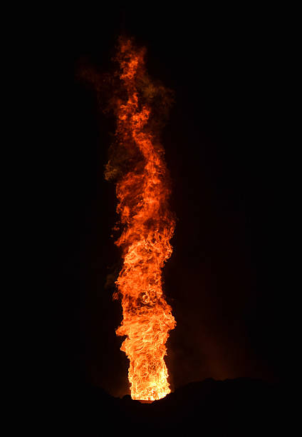 Blurred burning torch against the background of a blurred Mayan village. Ritual torch on the background of the jungle in defocus.