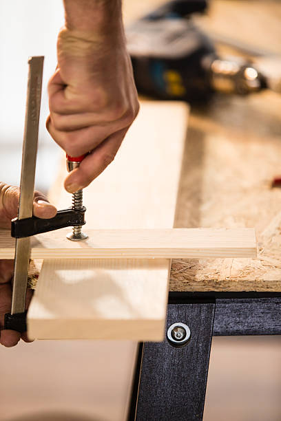 istock Carpenter adjusting clamp on wooden block 538024736