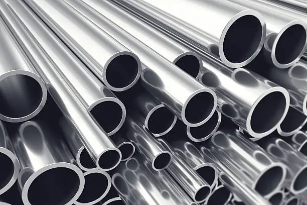 Photo of Heap of shiny metal steel pipes with selective focus effect