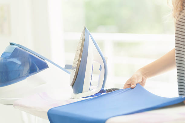 美しい女性一部の衣類のアイロンサービス - iron laundry cleaning ironing board ストックフォトと画像