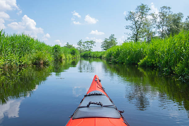 rosso kayak nel un canale in natura in primavera riserva - wieden weerribben foto e immagini stock