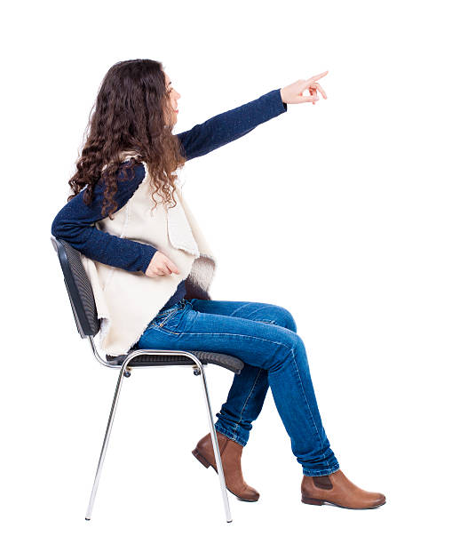 back view of young beautiful woman sitting on chair back view of young beautiful woman sitting on chair and pointing. girl watching. Rear view people collection. backside view of person. Isolated over white background. pics of girls buttocks stock pictures, royalty-free photos & images