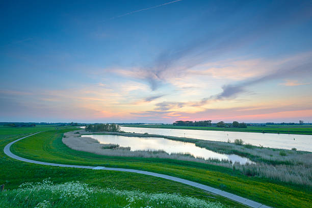 Colorful sunset over the IJsseldelta in Overijssel, The Netherla Colorful sunset over the IJsseldelta with the river IJssel in the foreground in Overijssel, The Netherlands ijssel stock pictures, royalty-free photos & images