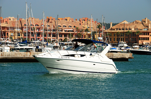 Puerto Sotogrande, Spain - July 18, 2008: Yachts and boats in the marina with buildings to the rear with people enjoying the setting, Puerto Sotogrande, Cadiz Province, Andalucia, Spain, Western Europe.