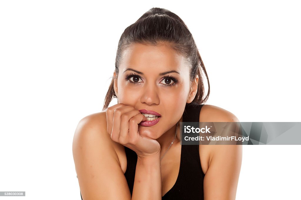 nibbling her nails dark skinned beautiful young women nibbling her nails on a white background Adult Stock Photo