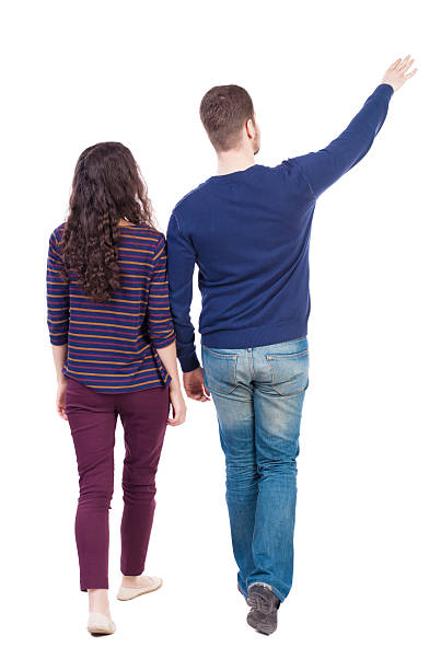 istock Back view of walking young couple (man and woman) pointing. 538030908