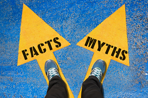 FACTS and MYTHS , Choice Concept , Two Yellow Arrows Painted on Asphalt showing different directions