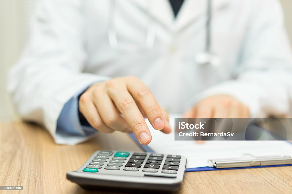 doctor is calculating cost of treatment Doctor Stock Photo