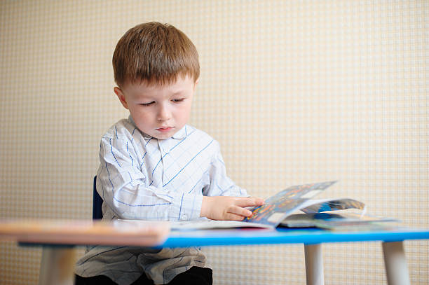 istock little boy at the desk reading a book 538032776