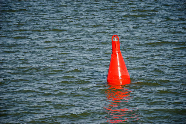 плавучий красный buoy на голубой воде - buoy anchored sea wave стоковые фото и изображения