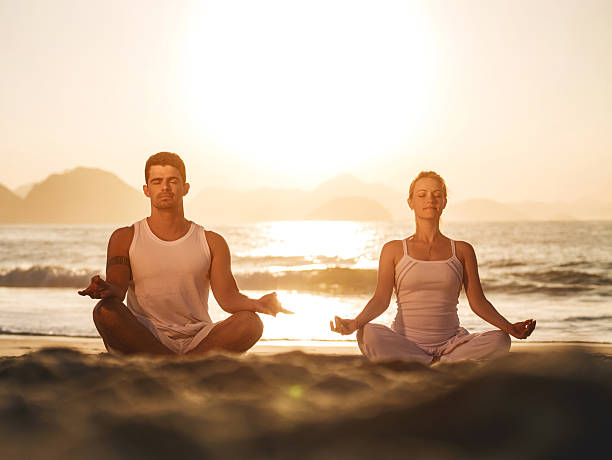 coppia esercizio di yoga al tramonto. - sunset yoga young men caucasian foto e immagini stock