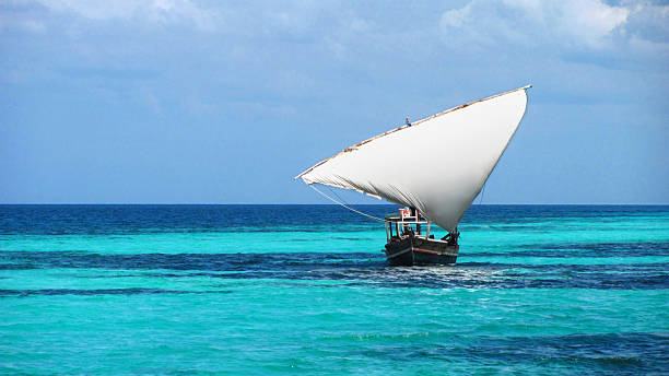 Zanzibar dhow local fisherman sailing boat blue turquoise sea Tanzania stock photo