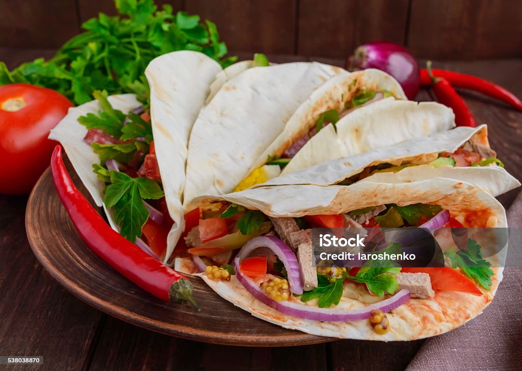 East pita bread with various fillings East pita bread with various fillings (meat, salami, egg, cucumber, parsley, tomato, chili pepper, Dijon mustard). Taco. Beef Stock Photo