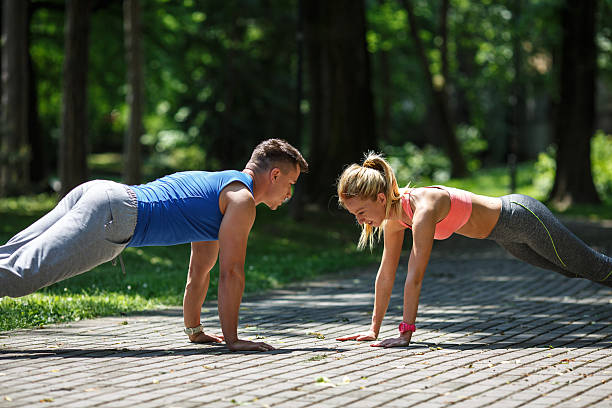 istock Couple doing push-ups at the park.Workout outdoors. 538040722