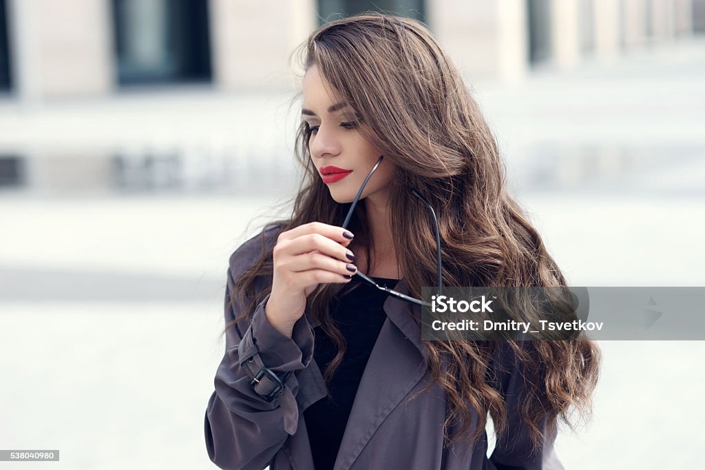 young pretty stylish girl in sunglasses Outdoor closeup fashion style portrait of young pretty stylish girl with long curly hair wearing sunglasses Women Stock Photo