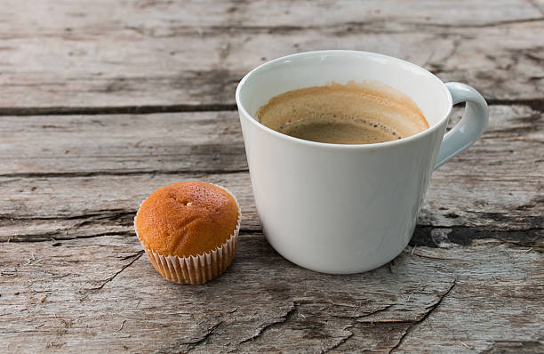 istock Cup of coffee and cupcake on a dark wooden surface. 538043288