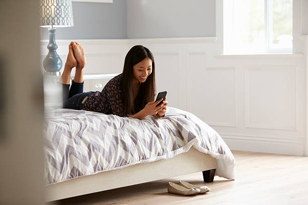 istock Woman Relaxing On Bed Checking Mobile Phone 538043632