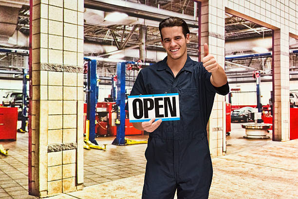 istock Smiling mechanic holding open sign 538043724