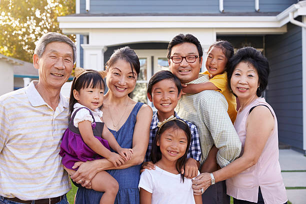 Portrait Of Family With Grandparents Standing Outside House Portrait Of Family With Grandparents Standing Outside House korean ethnicity photos stock pictures, royalty-free photos & images