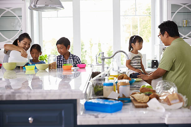 istock Family Having Breakfast And Making Lunches In Kitchen 538044588
